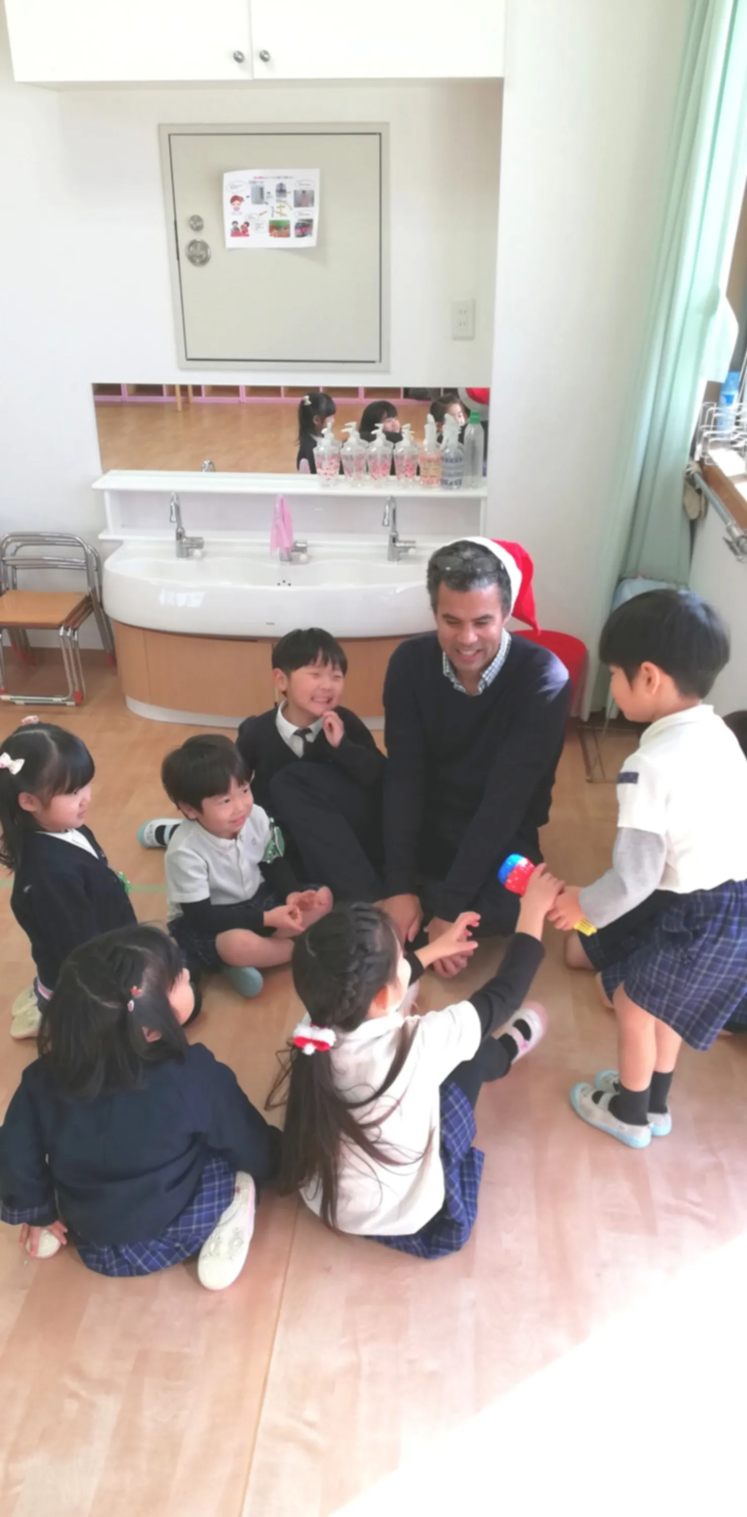 先生を囲んで英語で答える子どもたち